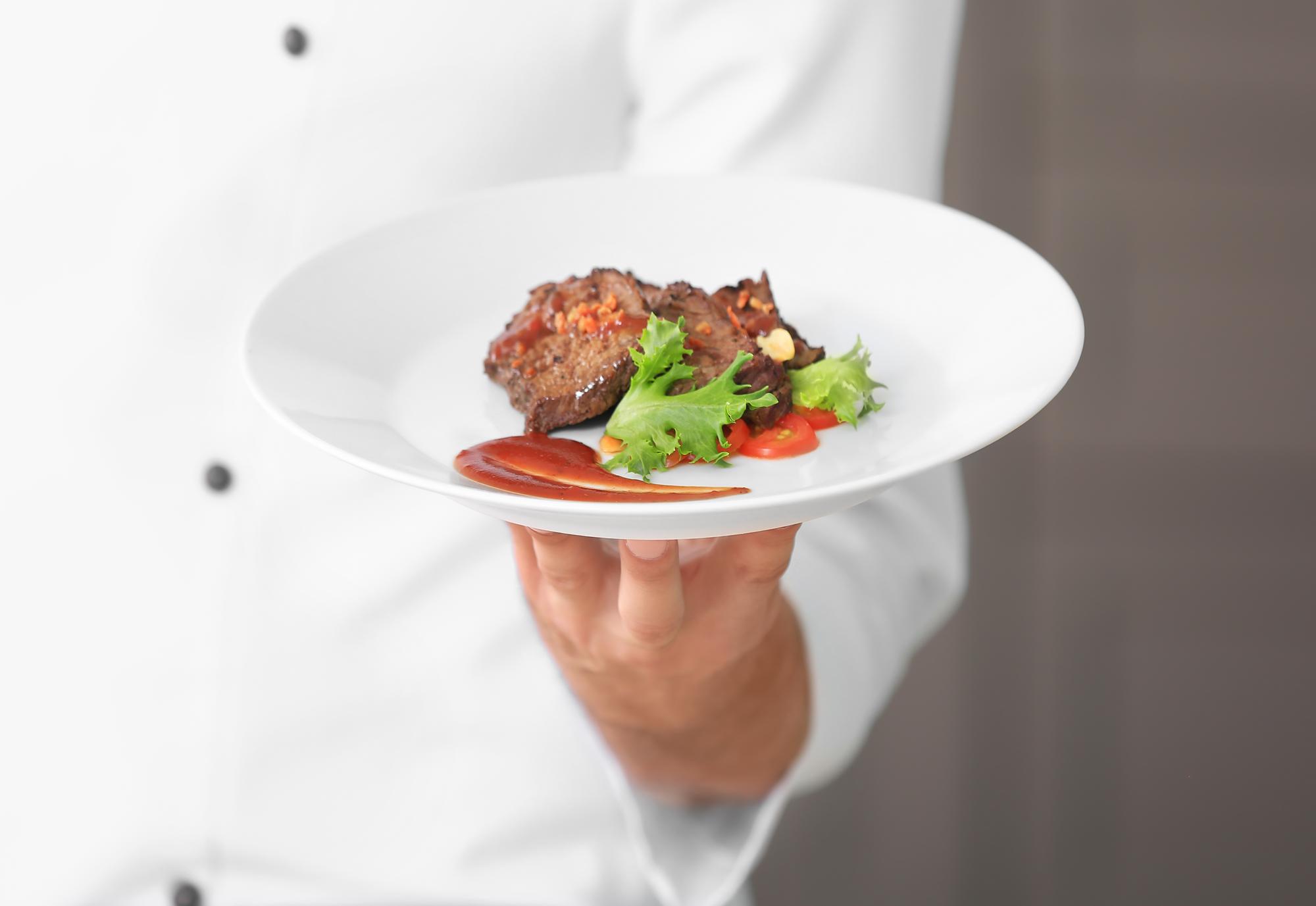 Chef preparing a quick plated dish in a clean kitchen